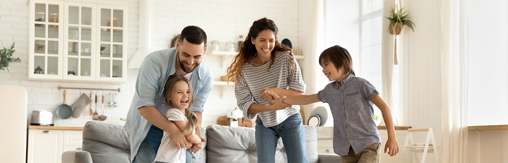 family smiling and dancing in living room